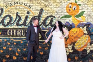 photo of wedding couple in front of florida citrus brick wall after getting married at disney springs
