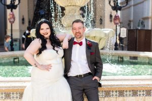 photography of bride and groom in front of a fountain after getting married at disney springs
