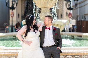 photography of bride and groom in front of a fountain after getting married at disney springs