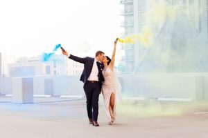 photo of wedding couple with smoke bombs at sunrise on the roof of parking garage in downtown orlando