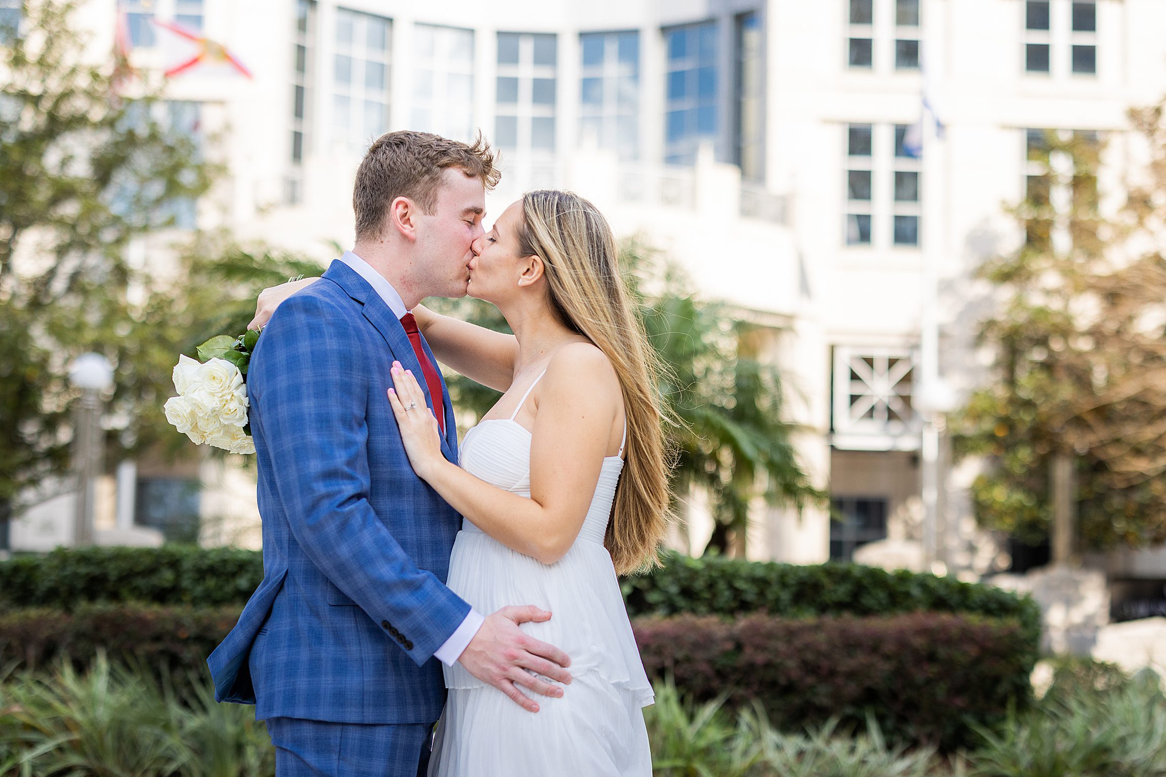 white couple kissing in front of the orange county courthouse in orlando florida
