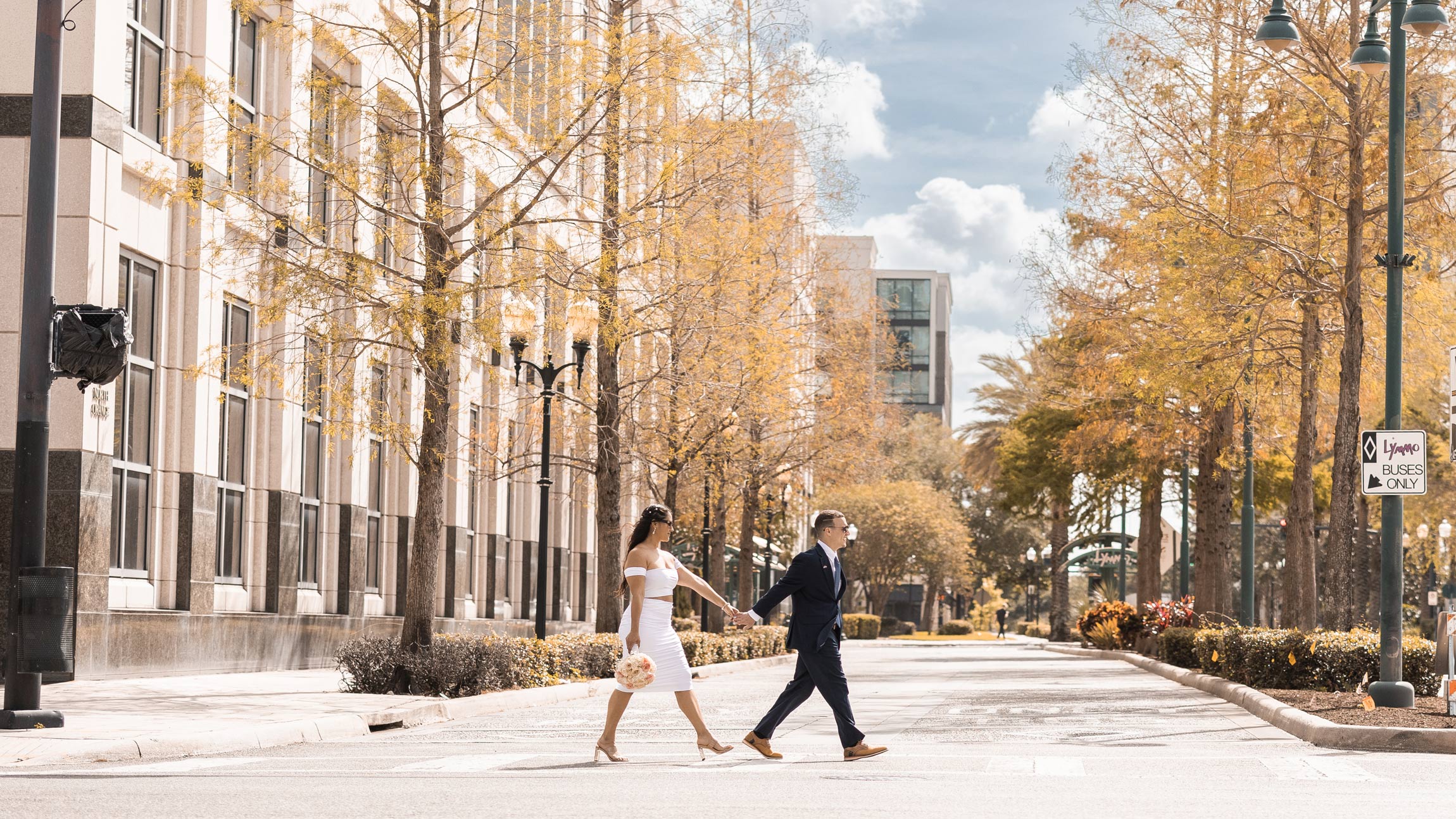couple walking across the road in downtown orlando after getting married at the courthouse