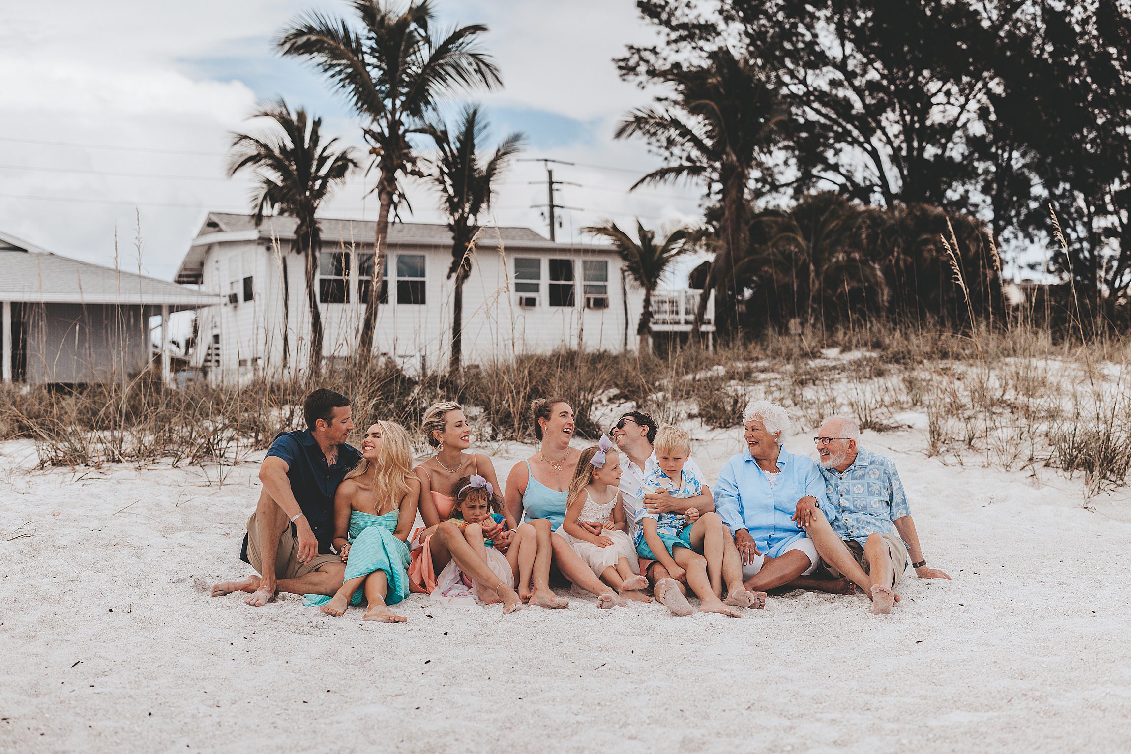 large extended family sitting on the sand on anna maria island