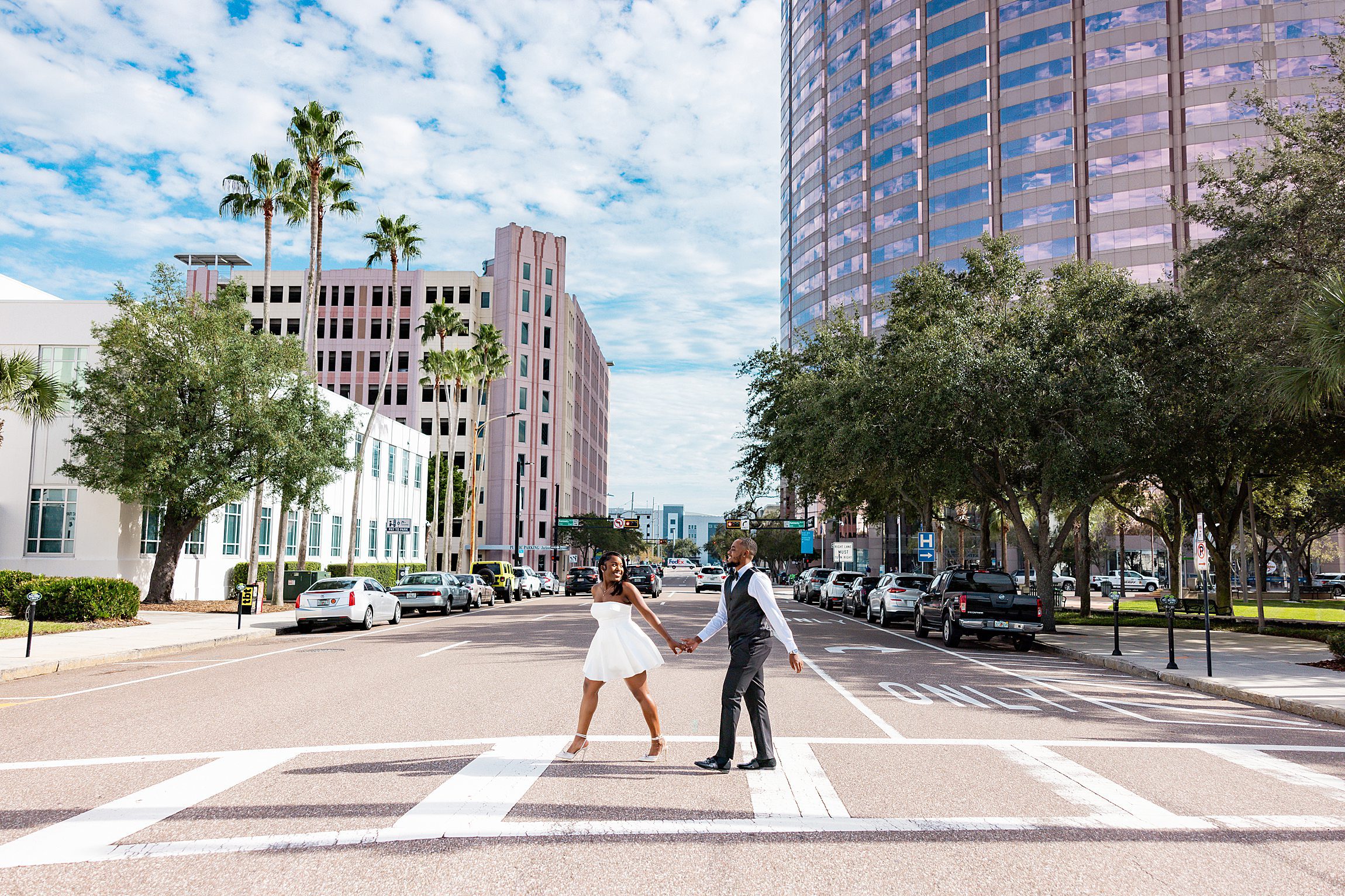 black couple walk across the road in downtown tampa after their hillsborough county courthouse wedding