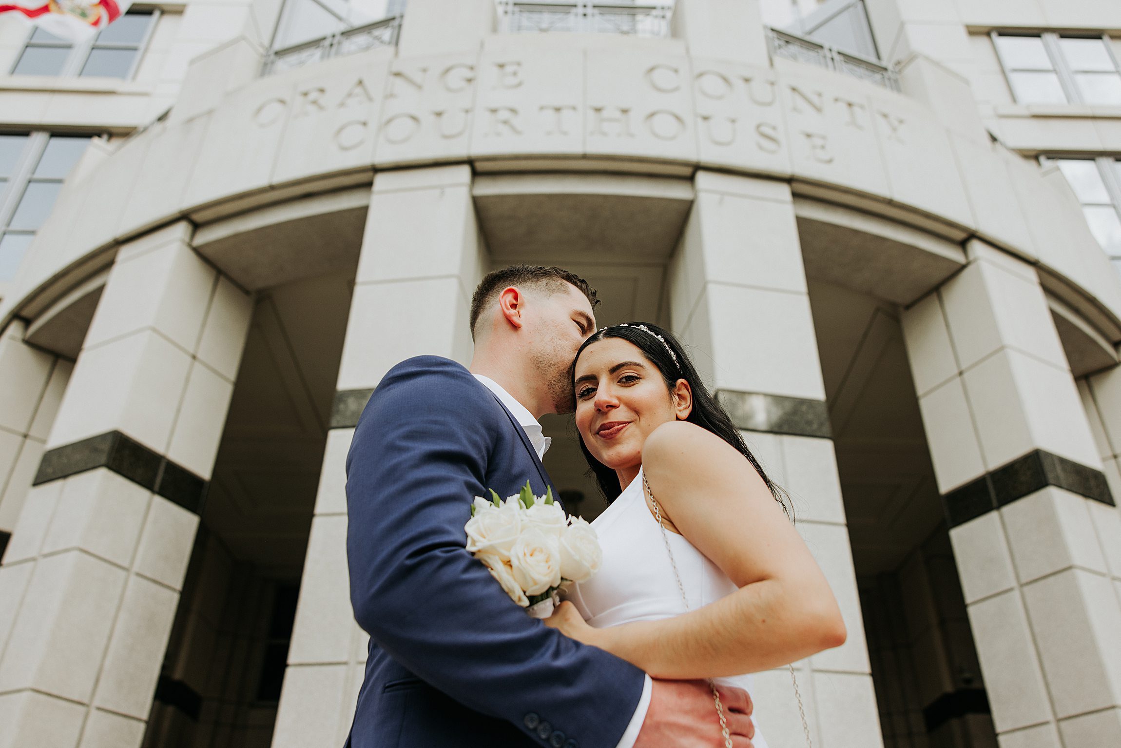 couple standing outside the orange county courthouse in downtown orlando after their courthouse wedding