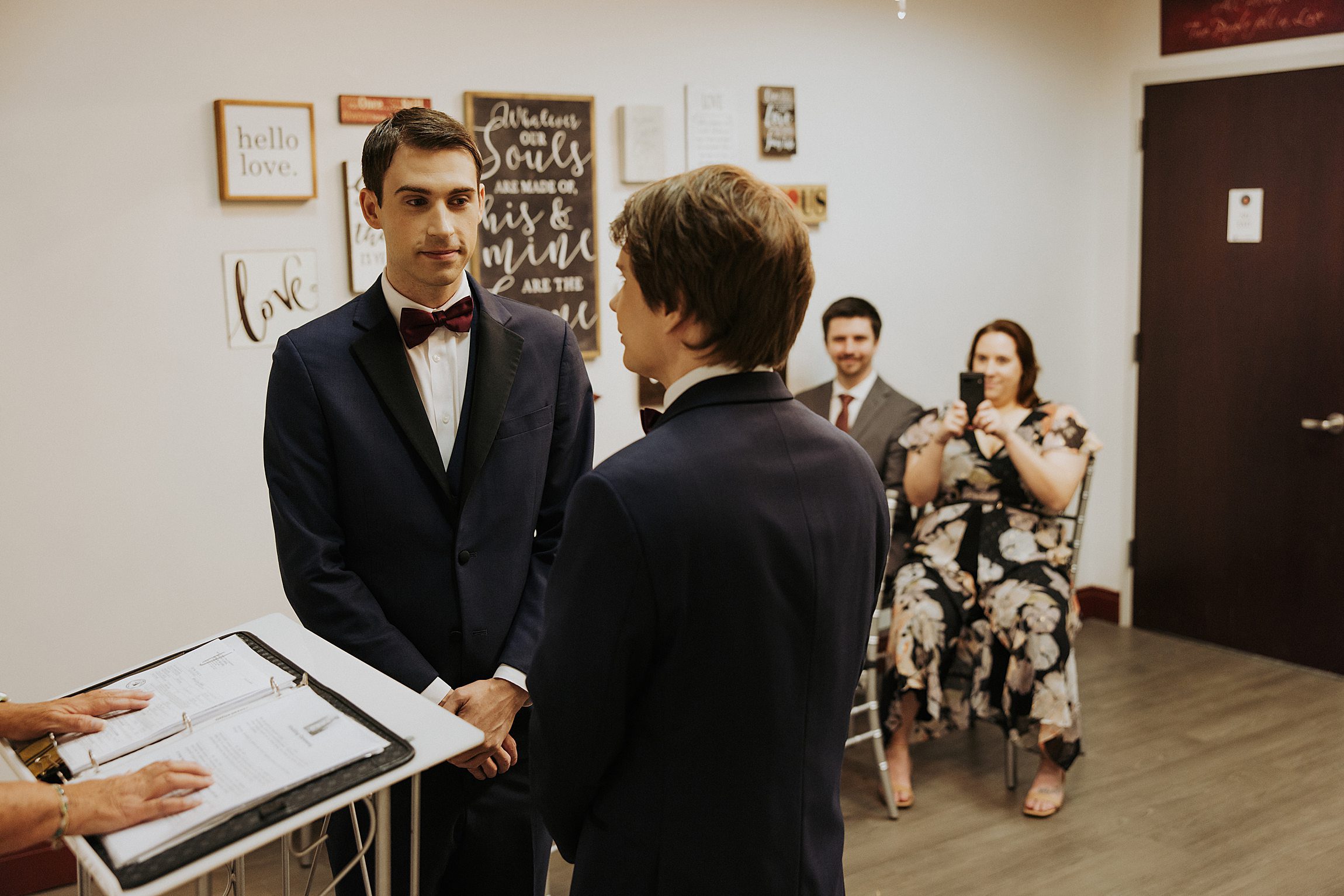 A gay couple standing in the ceremony room of the orange county courthouse for their wedding 