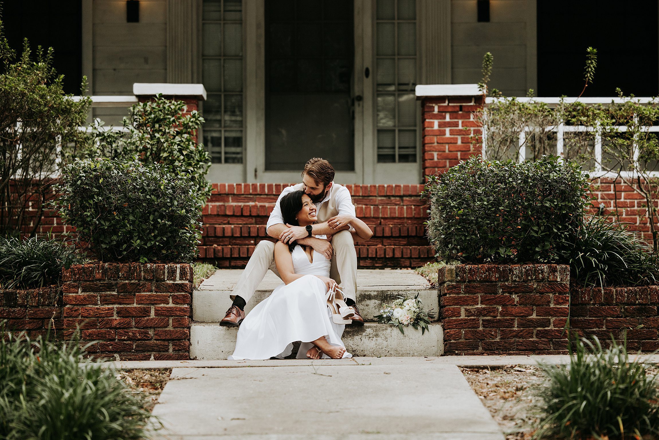 couple sitting on the steps of a house in the thornton park neighborhood of orlando after their elopement at the courthouse