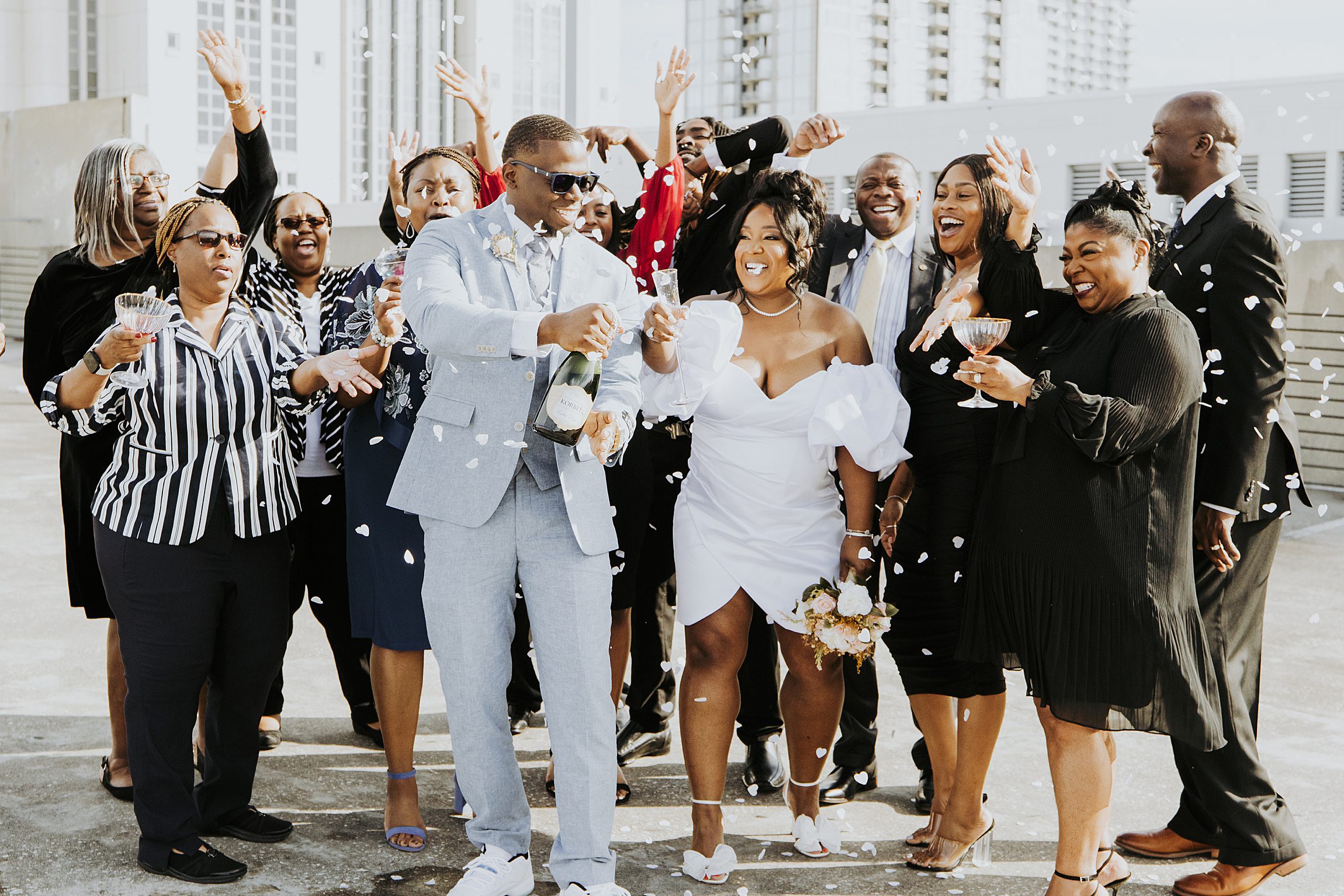 group of family and friends spraying champagne during a courthouse wedding in orlando