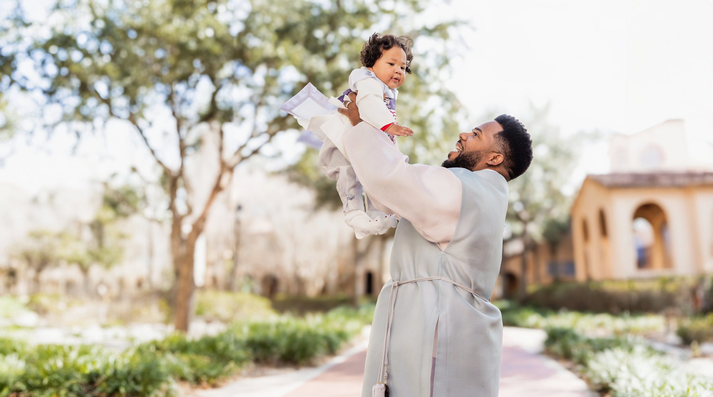 father wearing hanbok throwing baby in the air