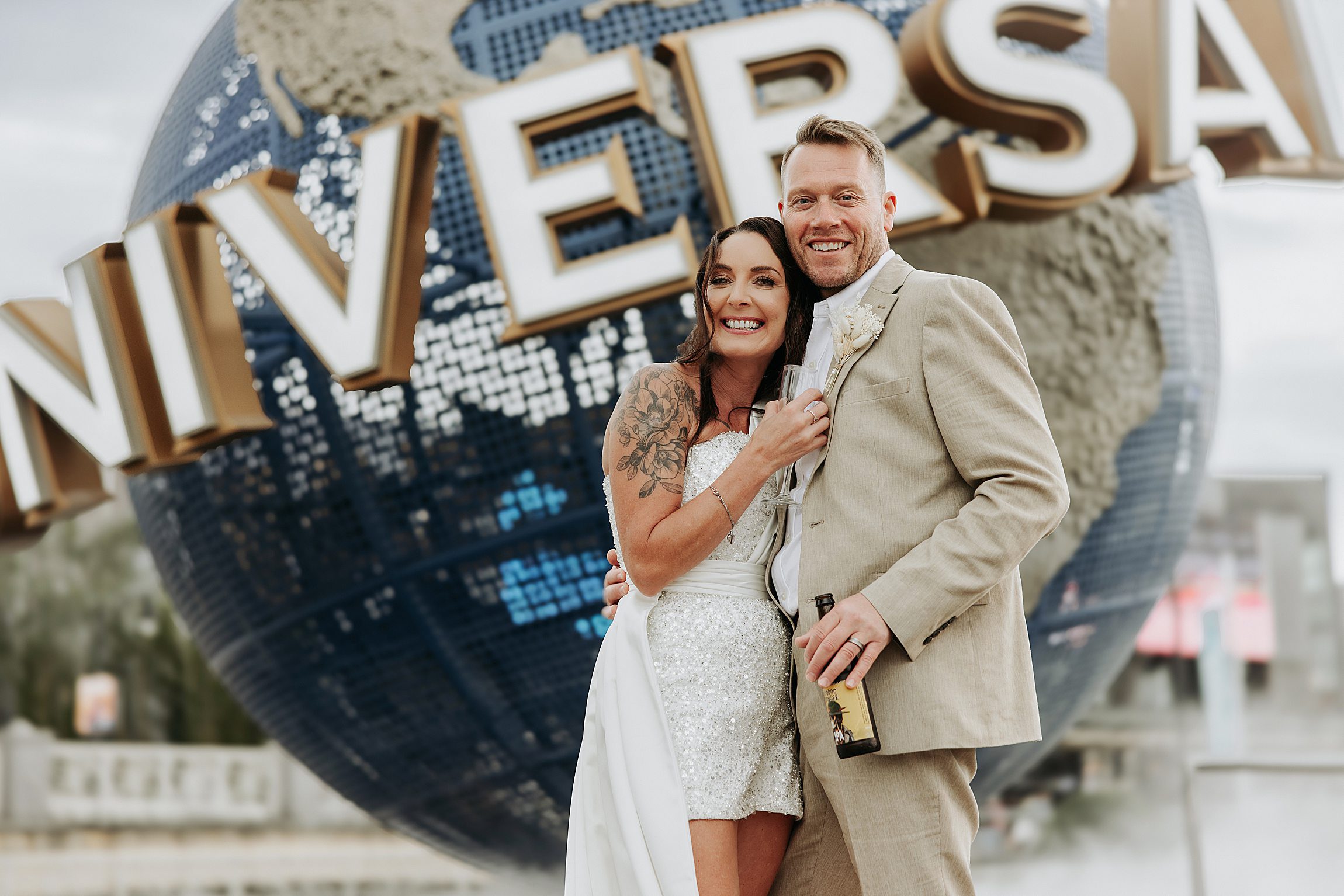 couple posing in front of the universal studios globe after their micro wedding at citywalk