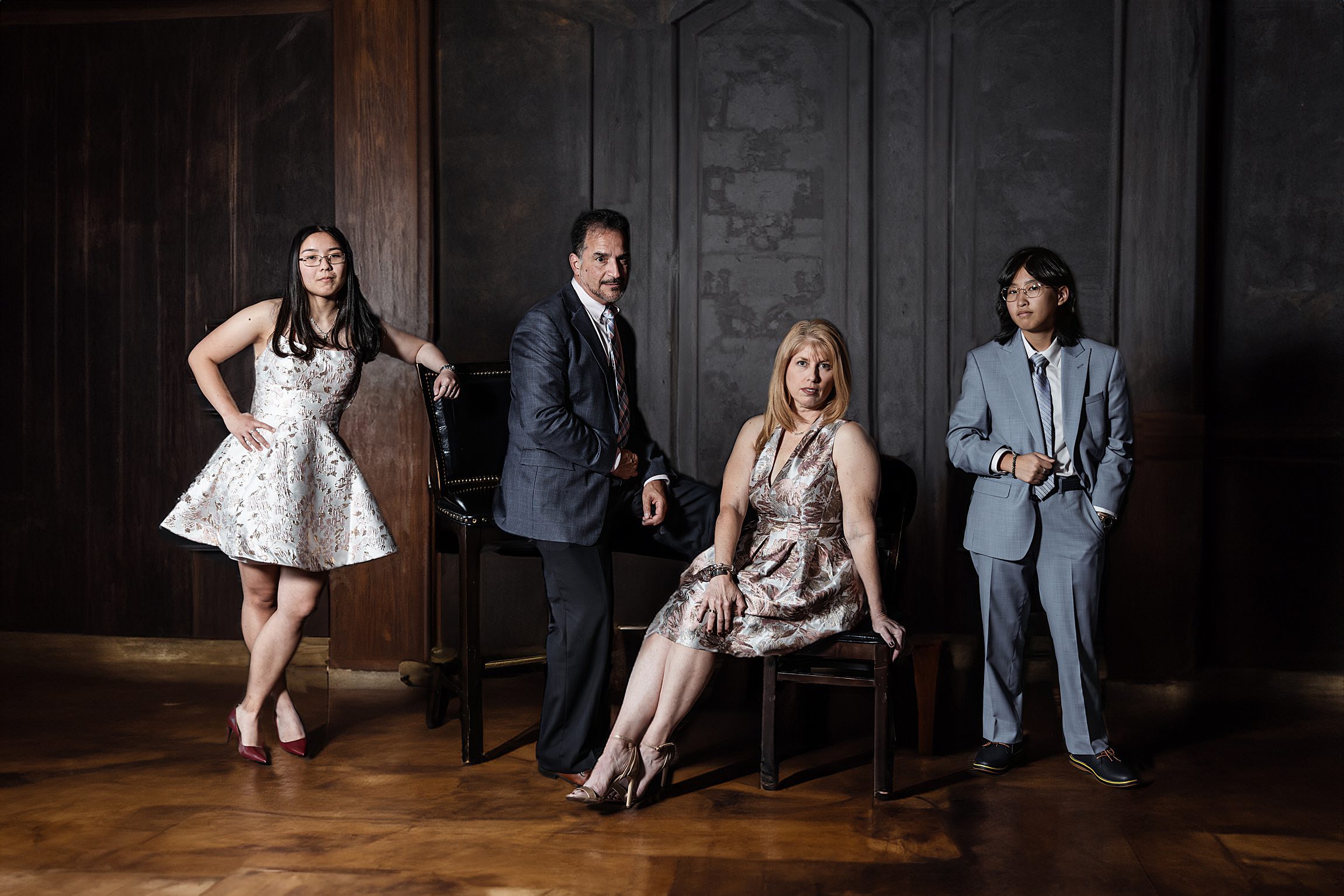 family of 4 posing in the banquet room at maggiano's little italy in a vogue style portrait