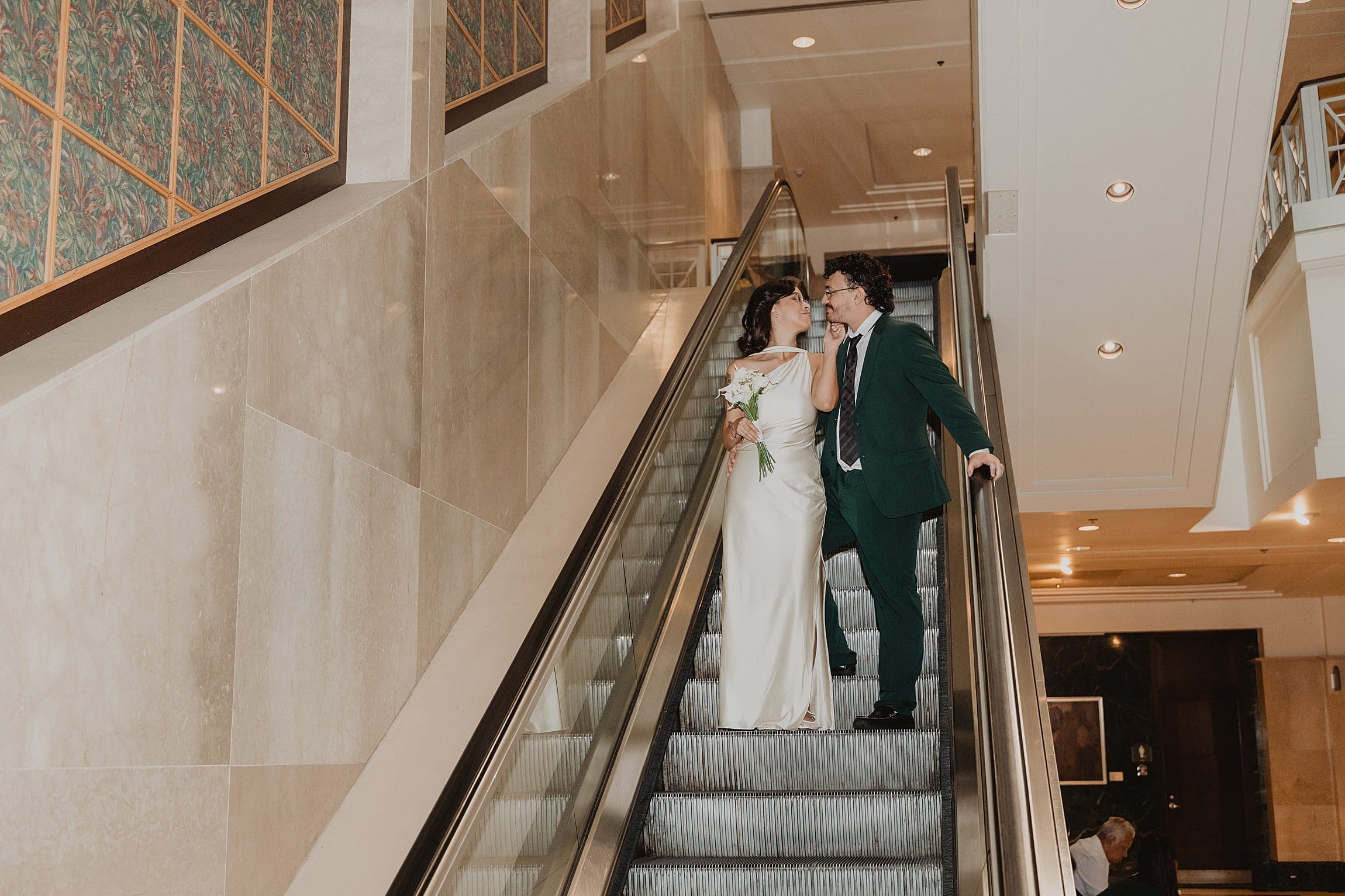newly married couple on the escalator in the orange county courthouse in downtown orlando before their wedding