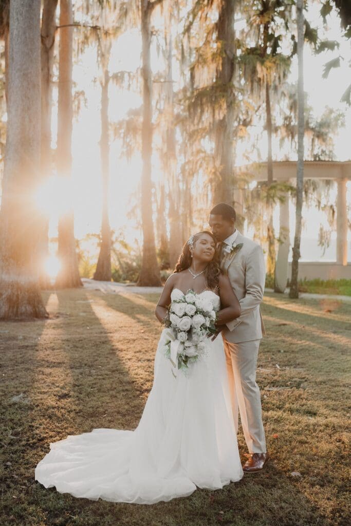 bride and groom embrace in front of the Exedra Monument during sunset golden hour at Kraft Azalea Garden in Winter Park, Florida, captured by Gracie May Photography