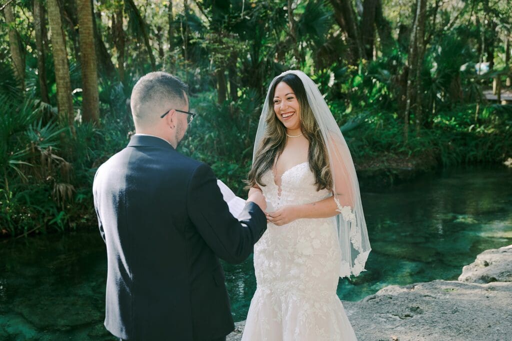 bride and groom during their intimate elopement ceremony in front of trees and the river at Kelly Park Rock Springs in Apopka Florida
