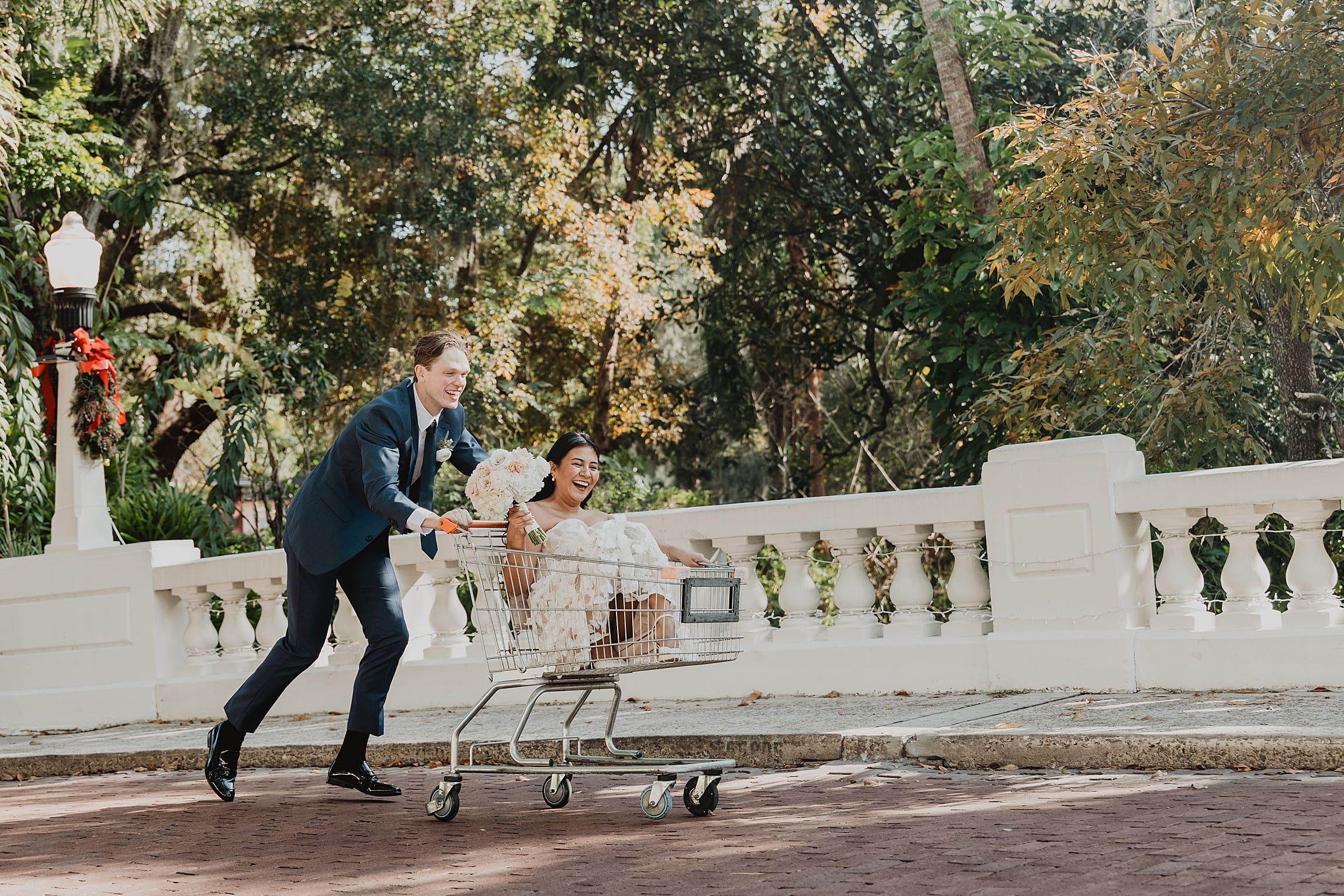 A quirky and fun elopement portrait of Jacob pushing Arely in a found shopping cart through an orlando street. This playful shot perfectly captures the "Type B" energy of their spontaneous wedding day.