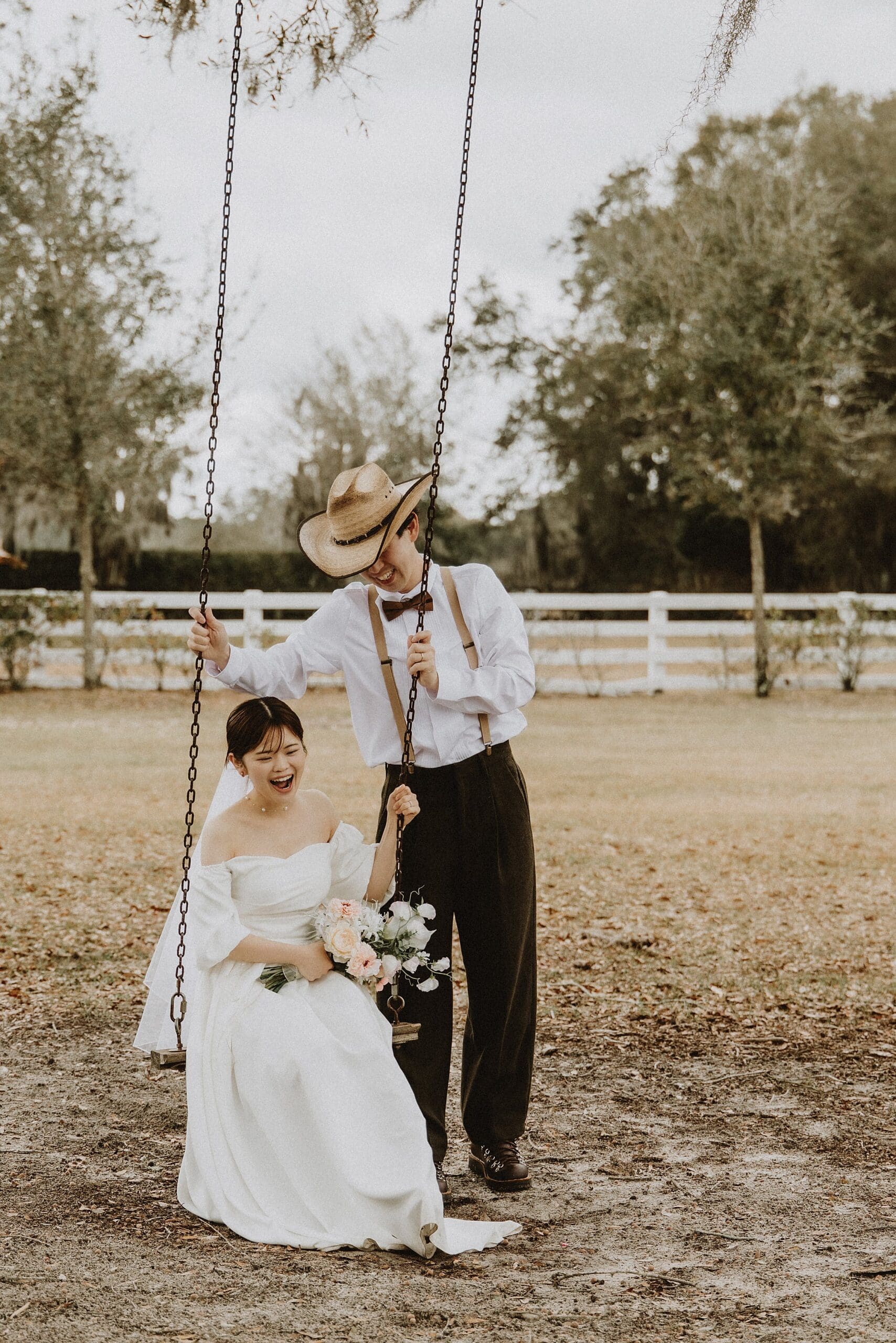bride and groom in a wedding dress and western wear on a swing at Horsepower Ranch in Geneva, Florida, captured by Gracie May Photography