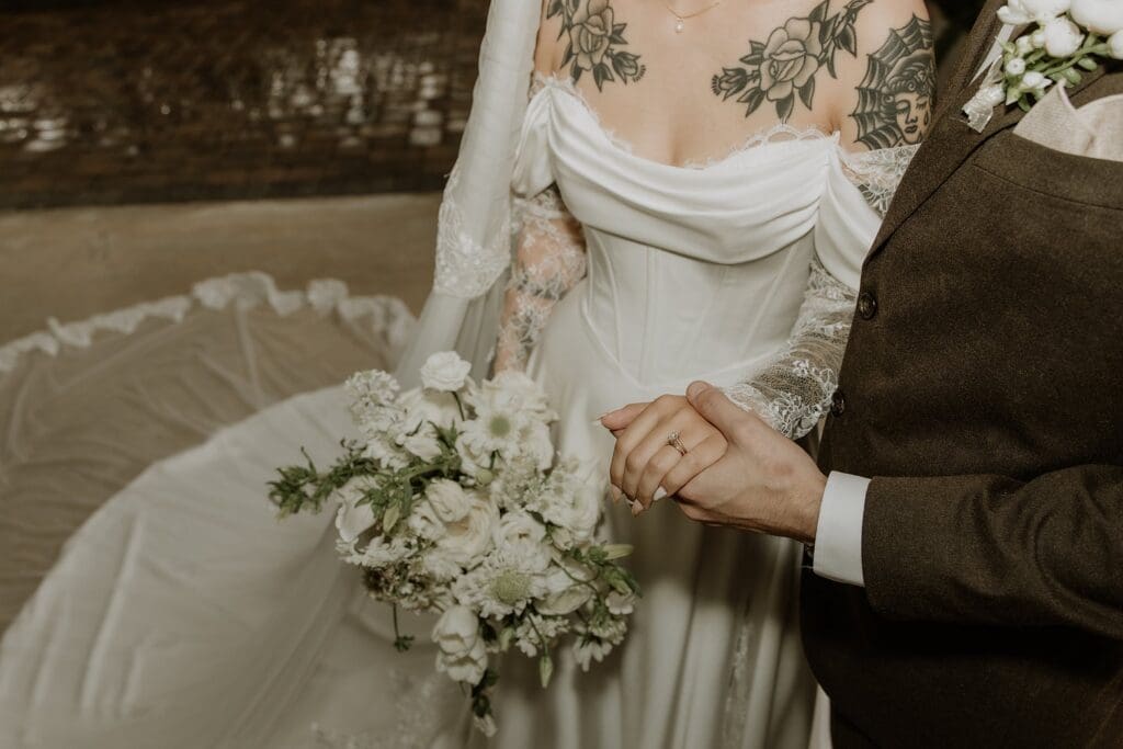bride in an off-the-shoulder gown with a white bouquet at this vintage style rainy day wedding at The Venue at Gentry Pines, captured by Gracie May Photography