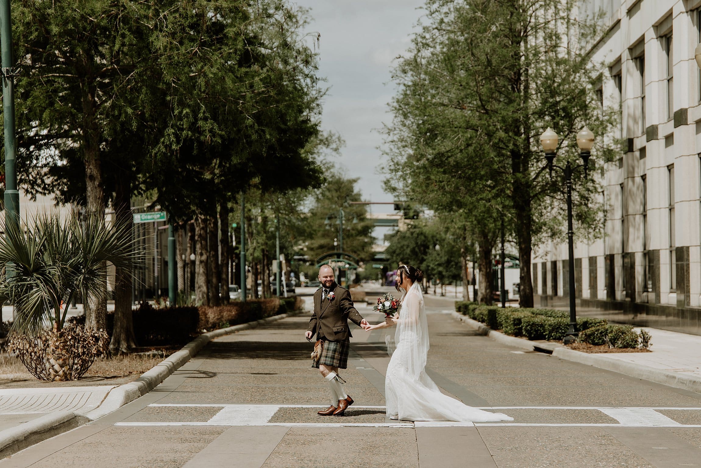 scottish couple walking across the road to their courthouse wedding at the orange county courthouse in downtown Orlando