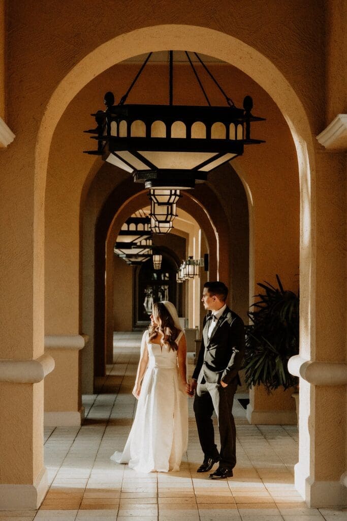 bride and groom in a grand hallway at the ritz carlton orlando during their wedding photoshoot