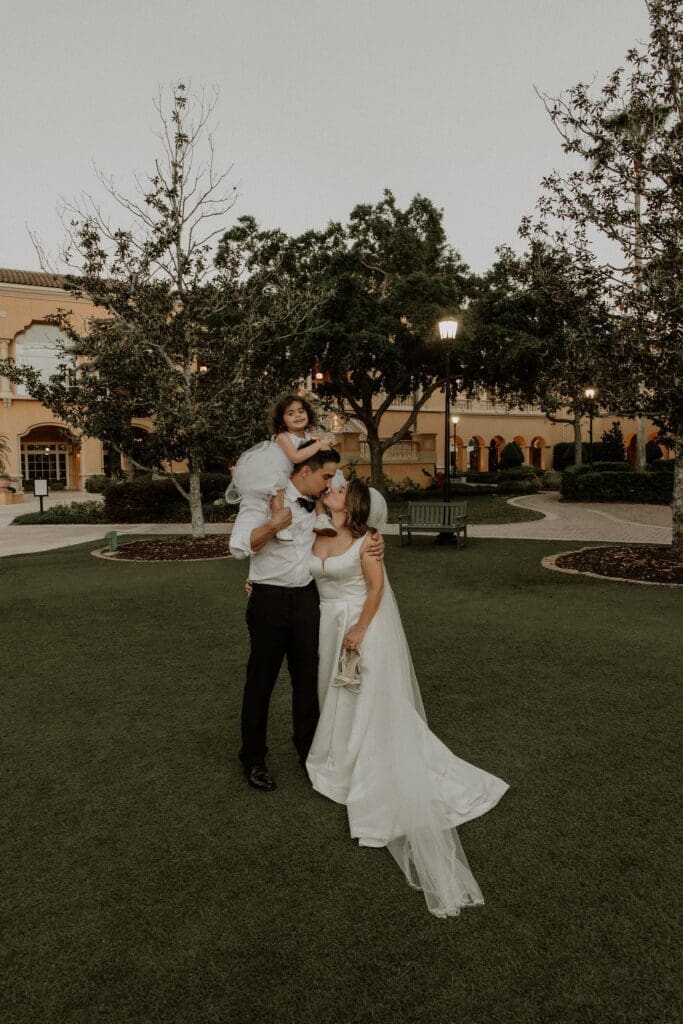 bride and groom with their toddler daughter at blue hour during their wedding photos at the ritz carlton orlando