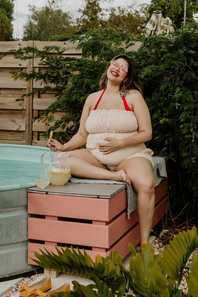 pregnant woman posing in a pool during their retro lavender pregnancy maternity photoshoot captured by Gracie May Photography