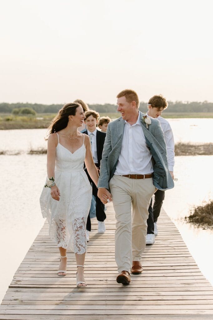 bride and groom and their kids on the dock at Lavender on the Lake in St Cloud, Florida, during their micro wedding ceremony captured by Gracie May Photography