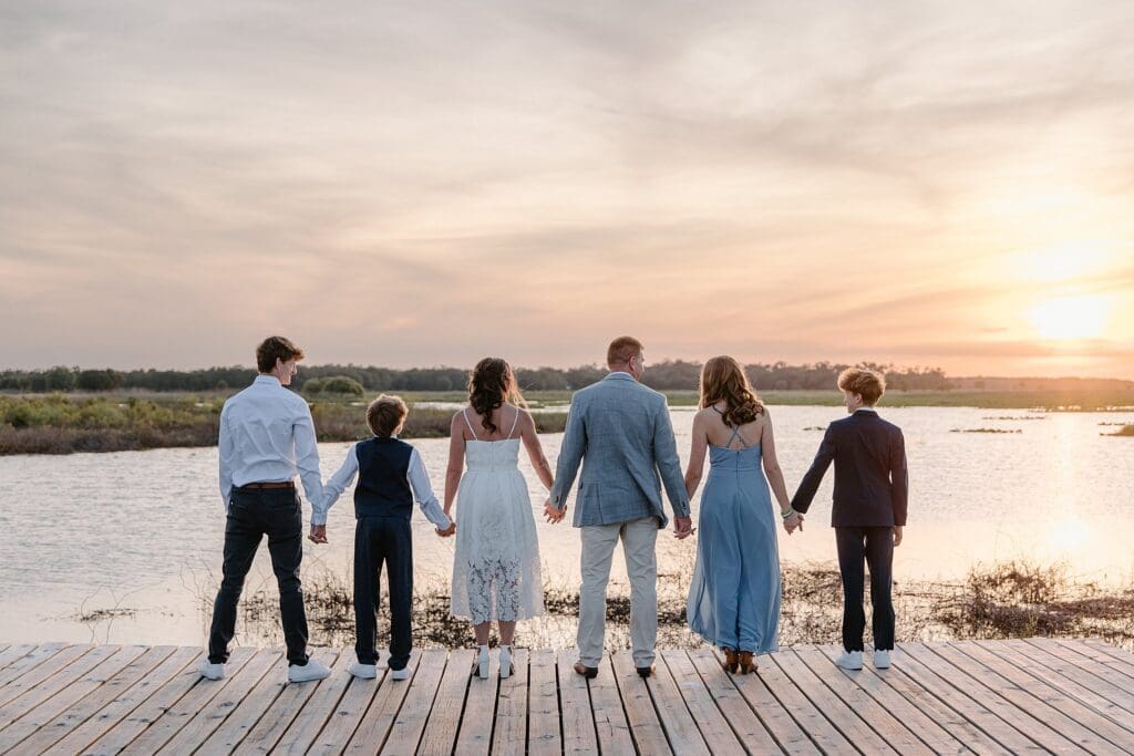 bride and groom and their kids on the dock at Lavender on the Lake in St Cloud, Florida, during their micro wedding captured by Gracie May Photography