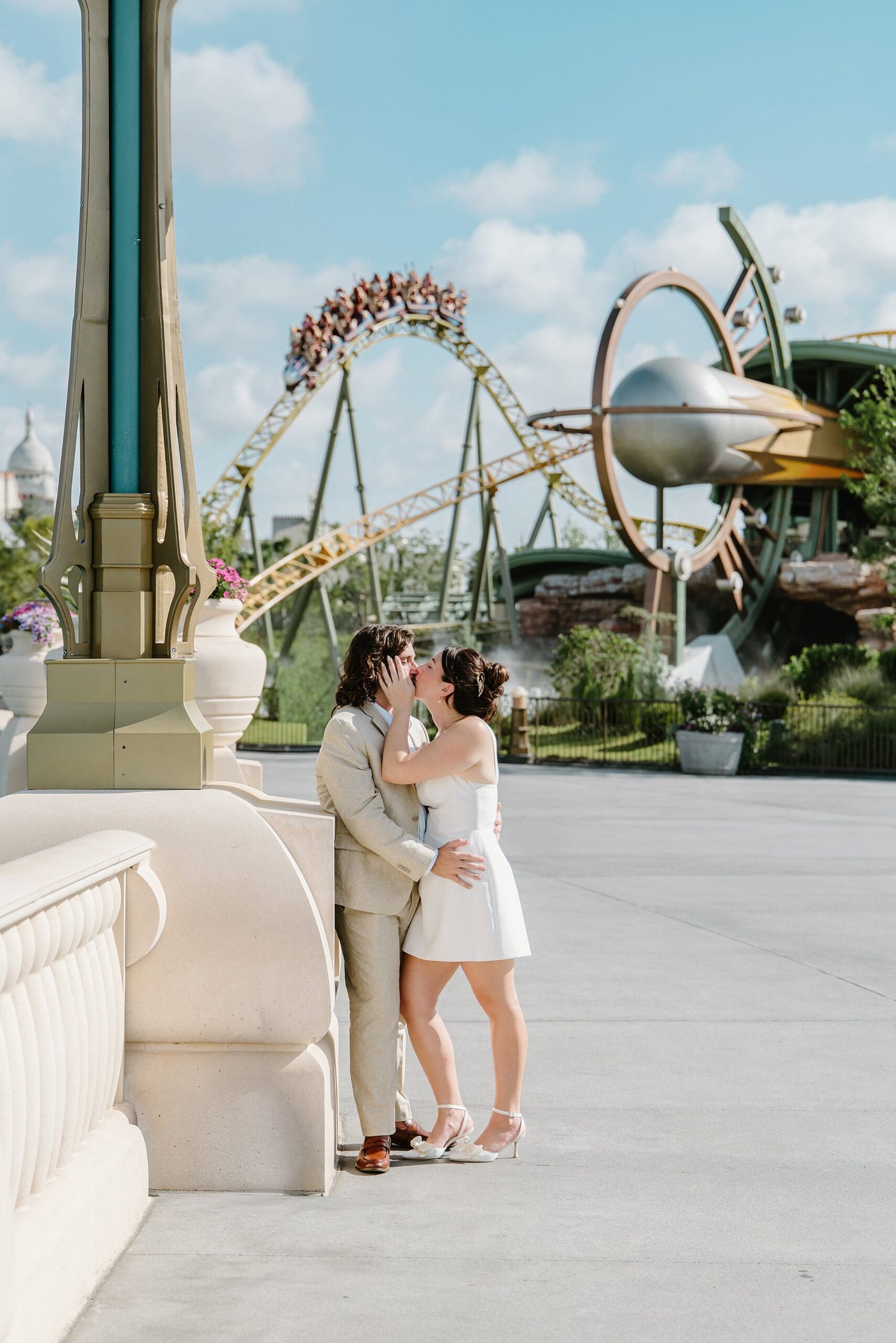 couple kissing in front of a roller coaster at epic universe