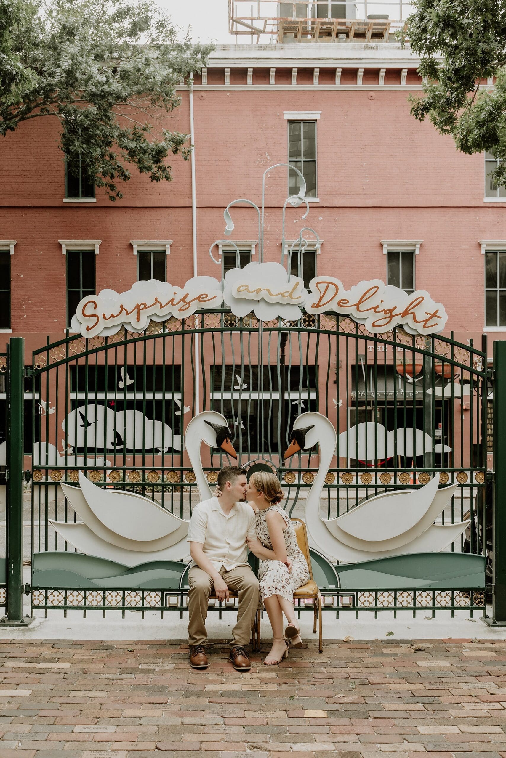 couple kissing during their engagement session at the swan iron gates at the cityarts building in downtown orlando