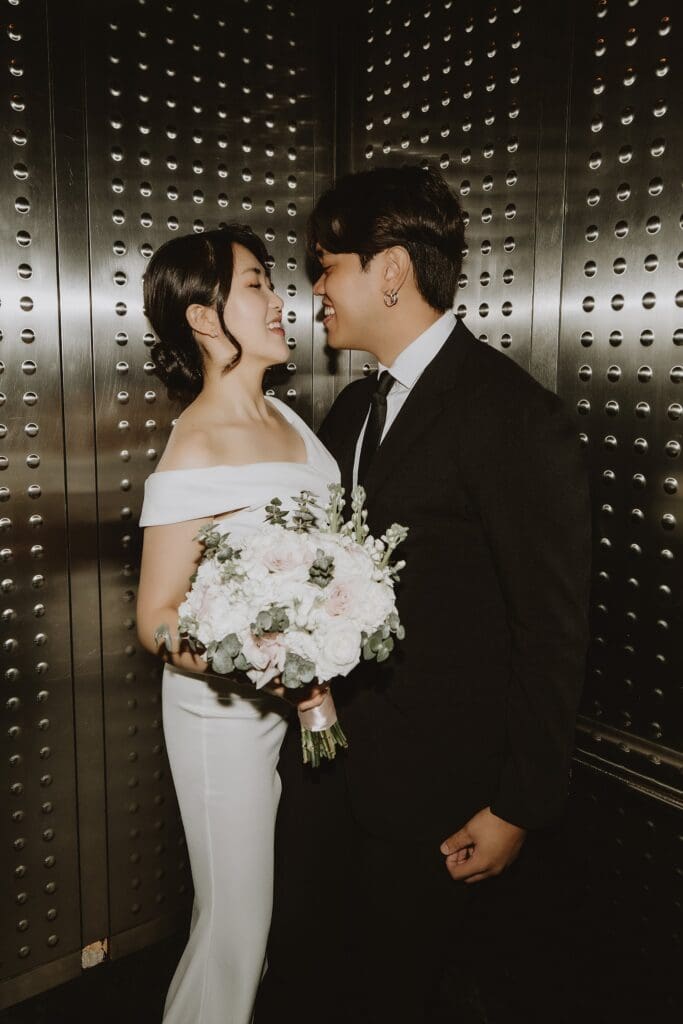 bride and groom playfully embrace inside an elevator in the Orlando Orange County Courthouse, captured by Gracie May Photography