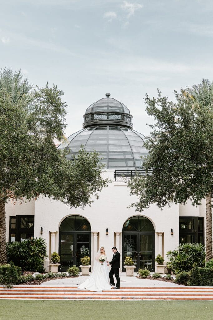 newly married couple in front of the dome during their hotel exterior photos at the alfond inn