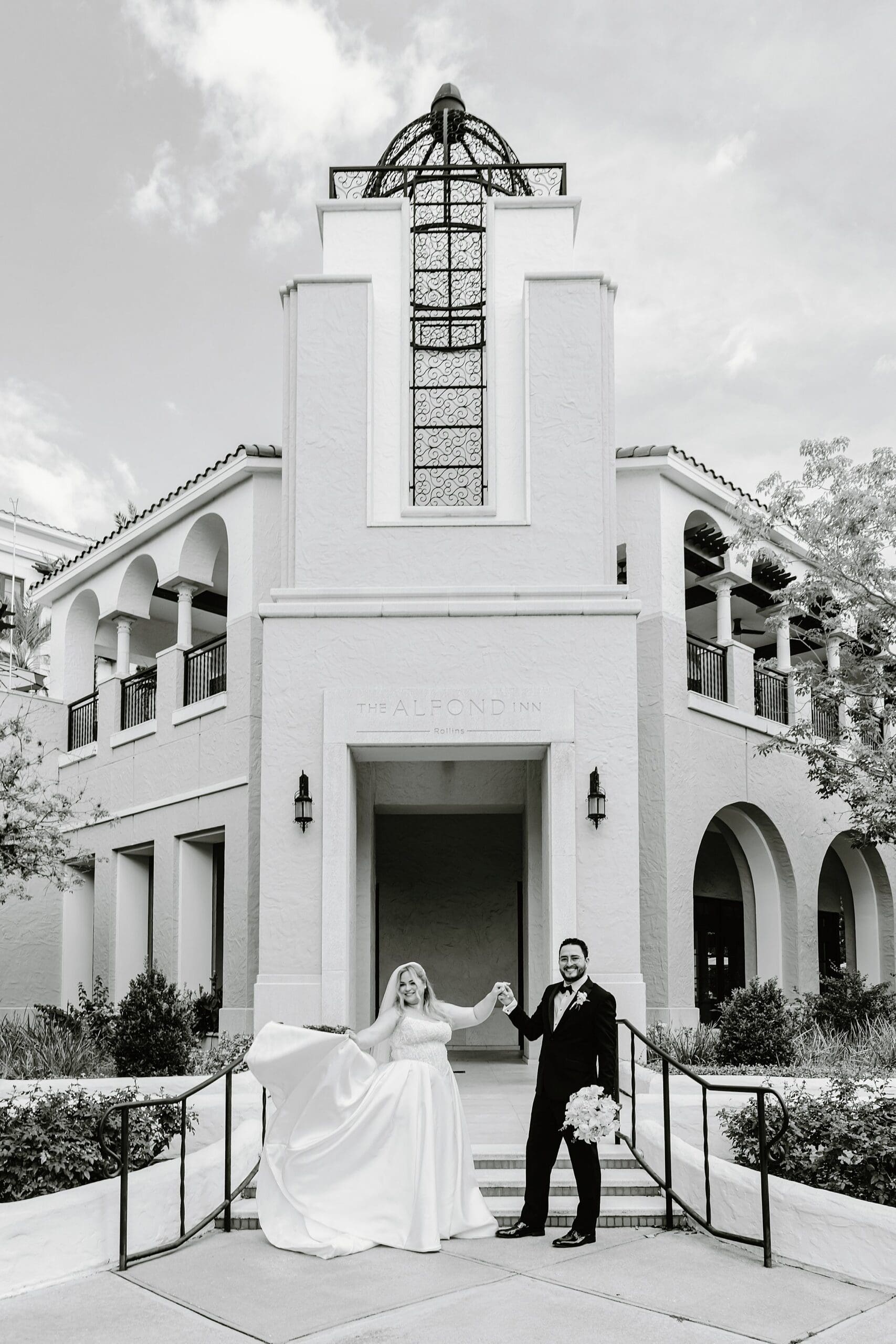 black and white photo of a couple during their wedding outside the front entrance of the alfond inn in winter park