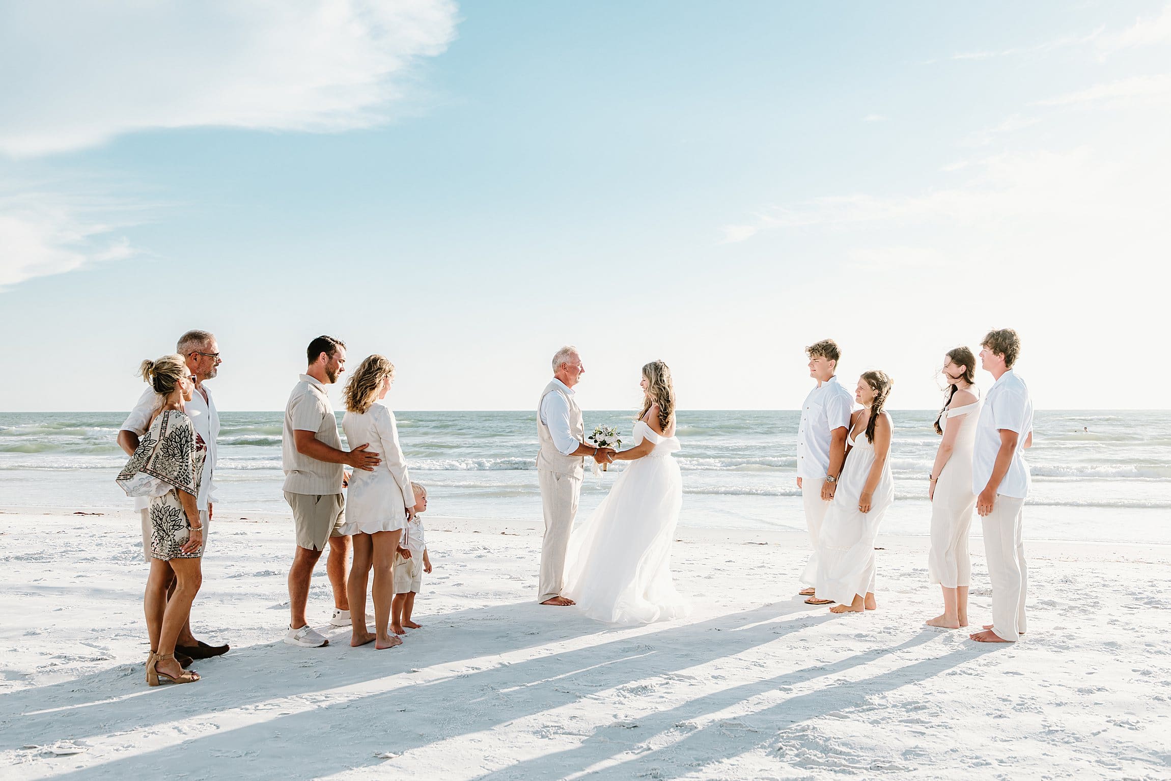 couple and their family during their wedding ceremony on the beach at siesta key in sarasota