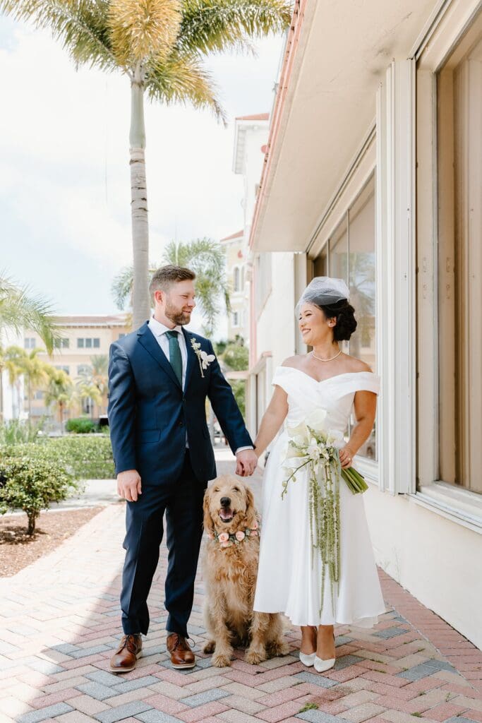 bride and groom with their dog on the palm-lined streets of downtown Fort Pierce, Florida, captured by Gracie May Photography